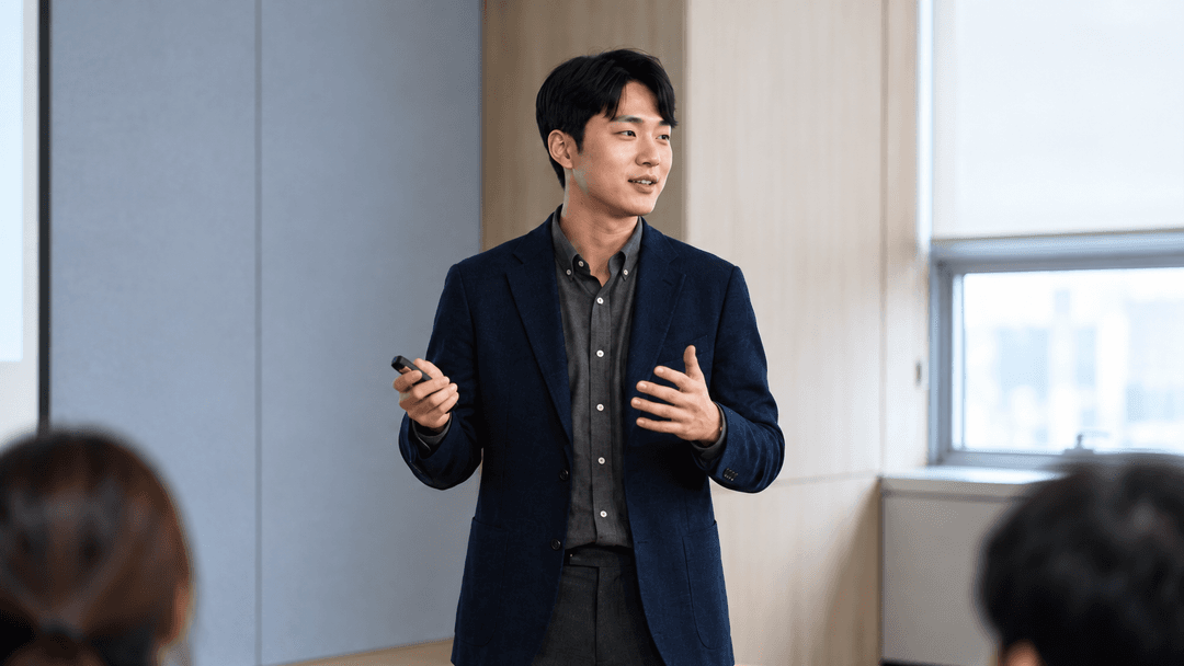 스크린 앞에서 발표 중인 사람